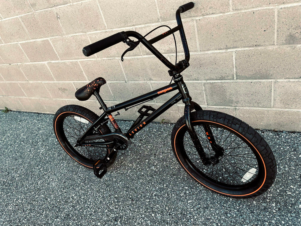 Front view of a Mongoose Legion L60 BMX Bike with a 20-inch freestyle frame, featuring black and red design elements.